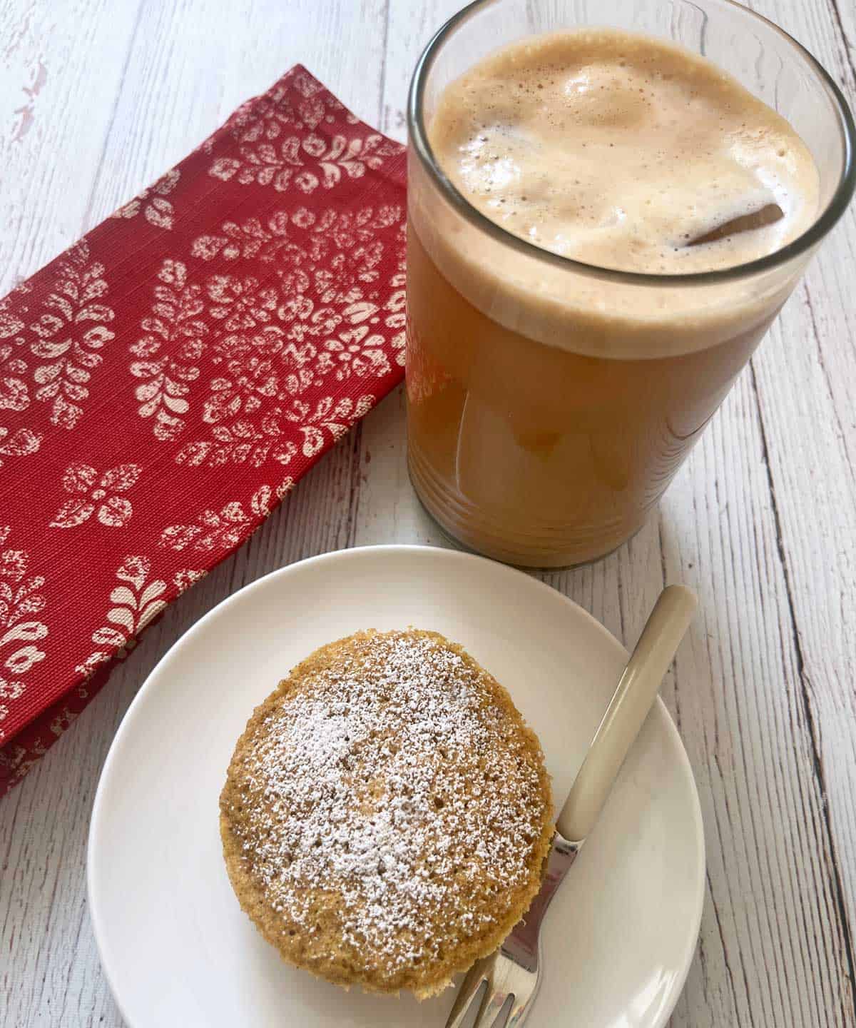 Iced coffee is served with a mug cake.