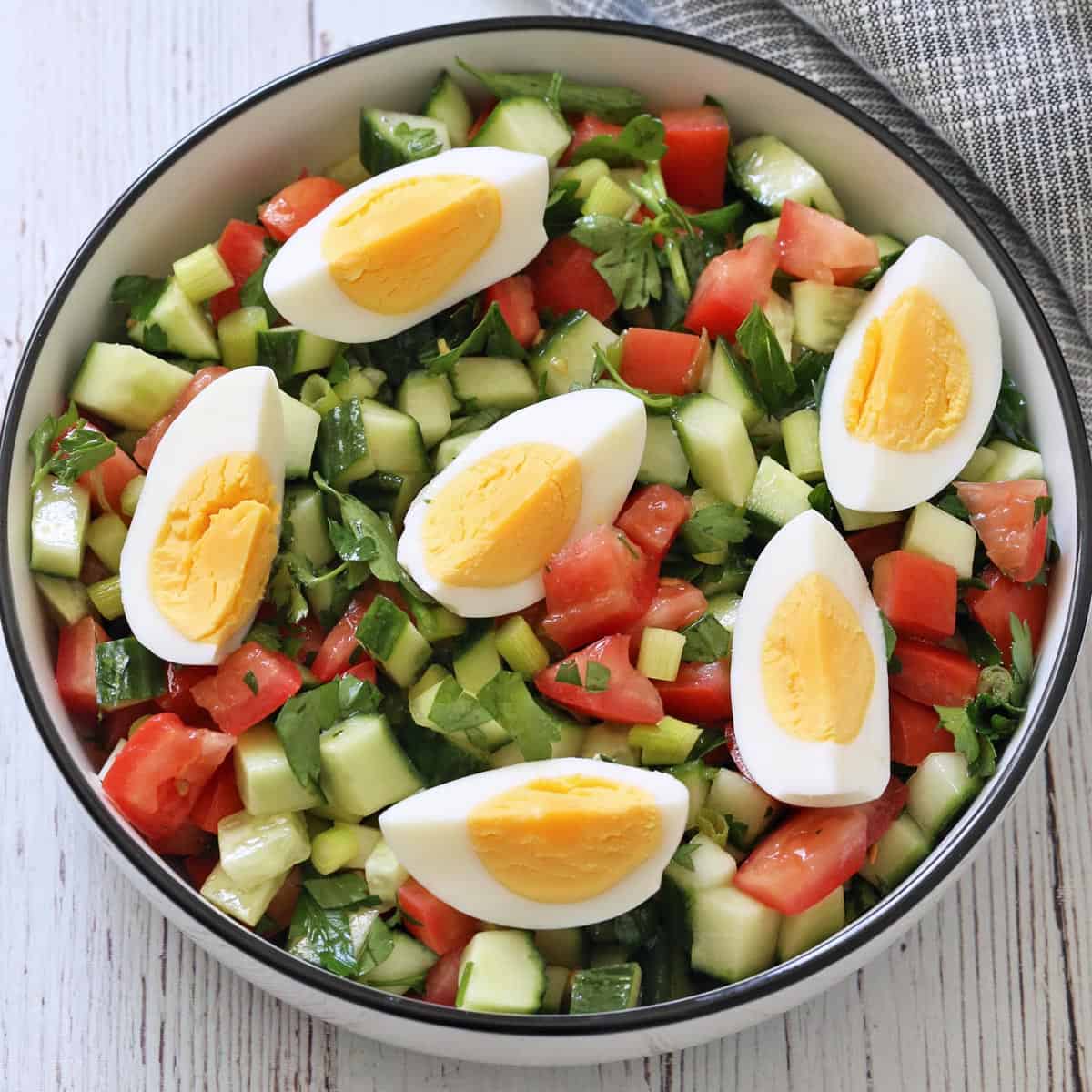 Israeli salad is topped with hard-boiled eggs.