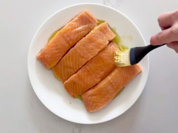 Coating the salmon in olive oil.
