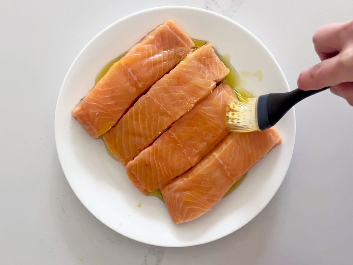 Coating the salmon in olive oil.