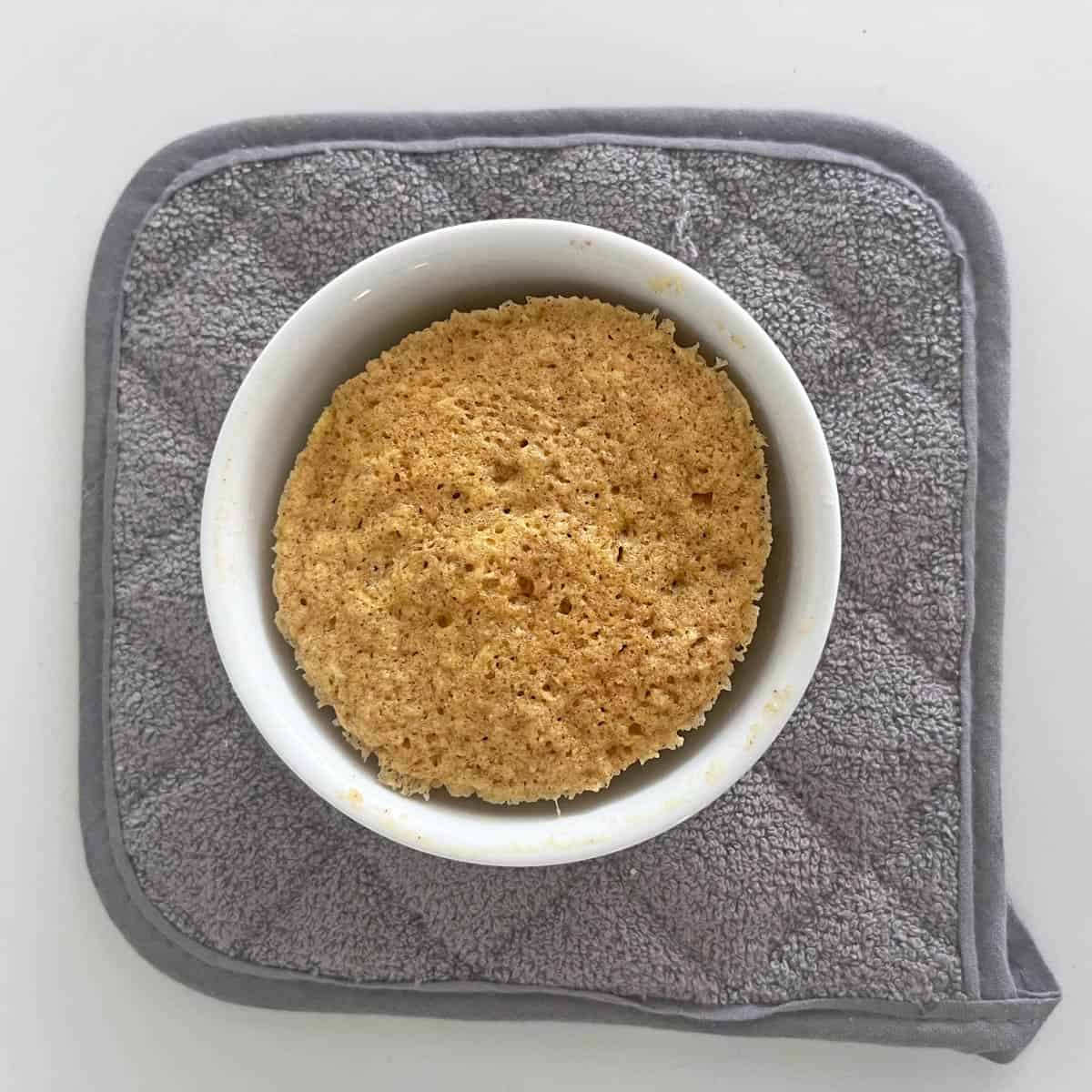 Placing the mug cake on a trivet.