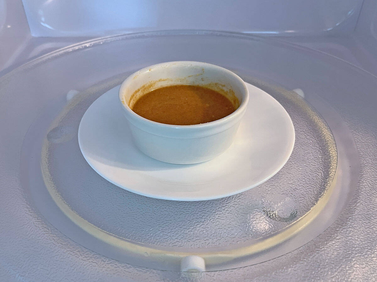 Placing the ramekin on a plate in the microwave to catch spills.