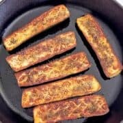 Roasted zucchini is served in a skillet.