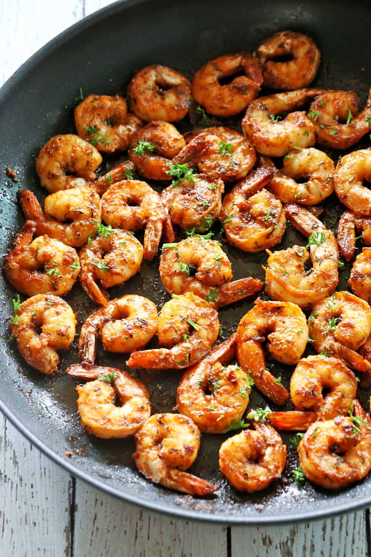 Sautéed shrimp are served in a skillet.