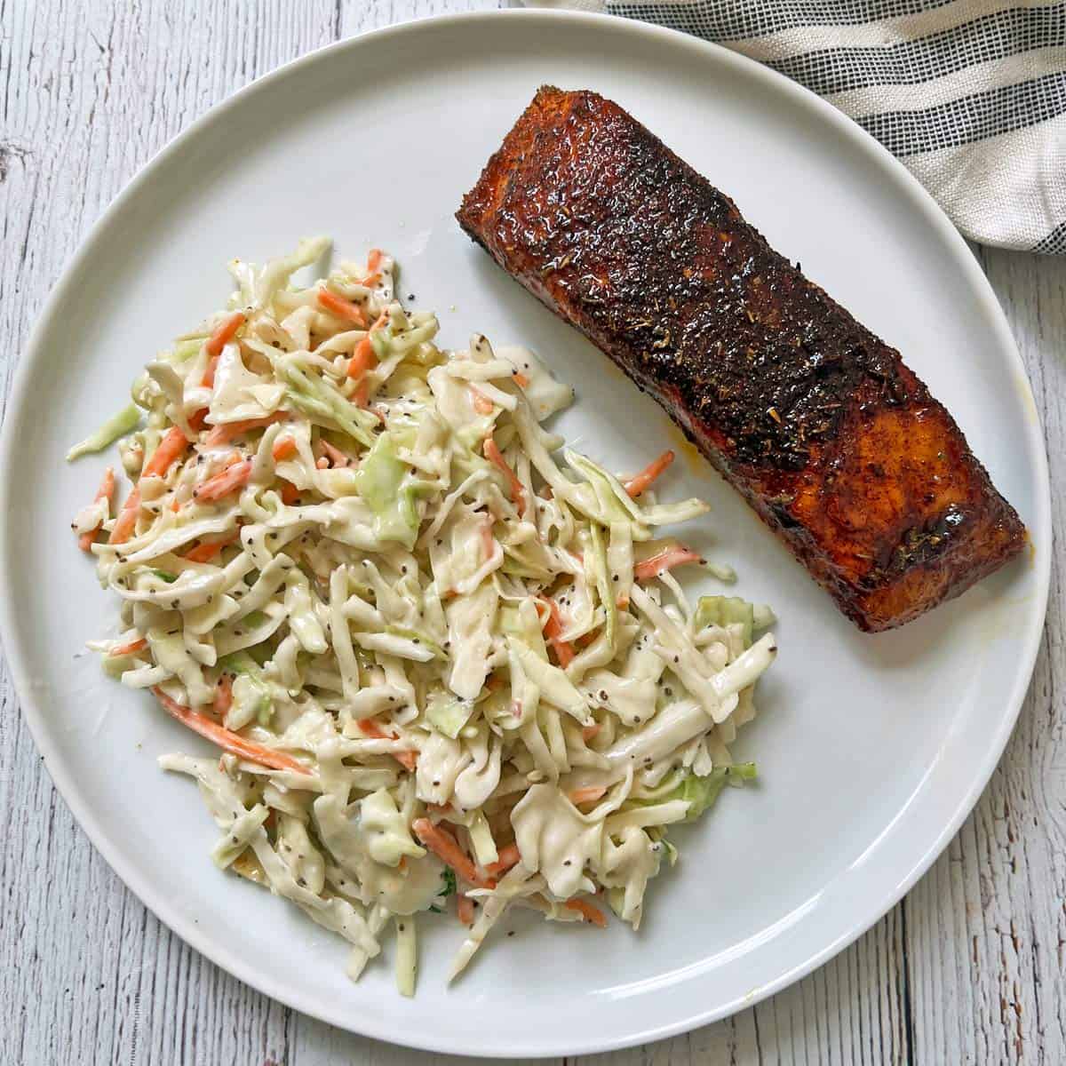 Blackened salmon is served with coleslaw.