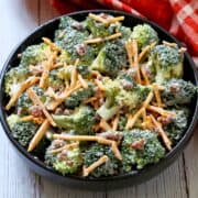Broccoli salad is served in a black bowl with a red napkin.
