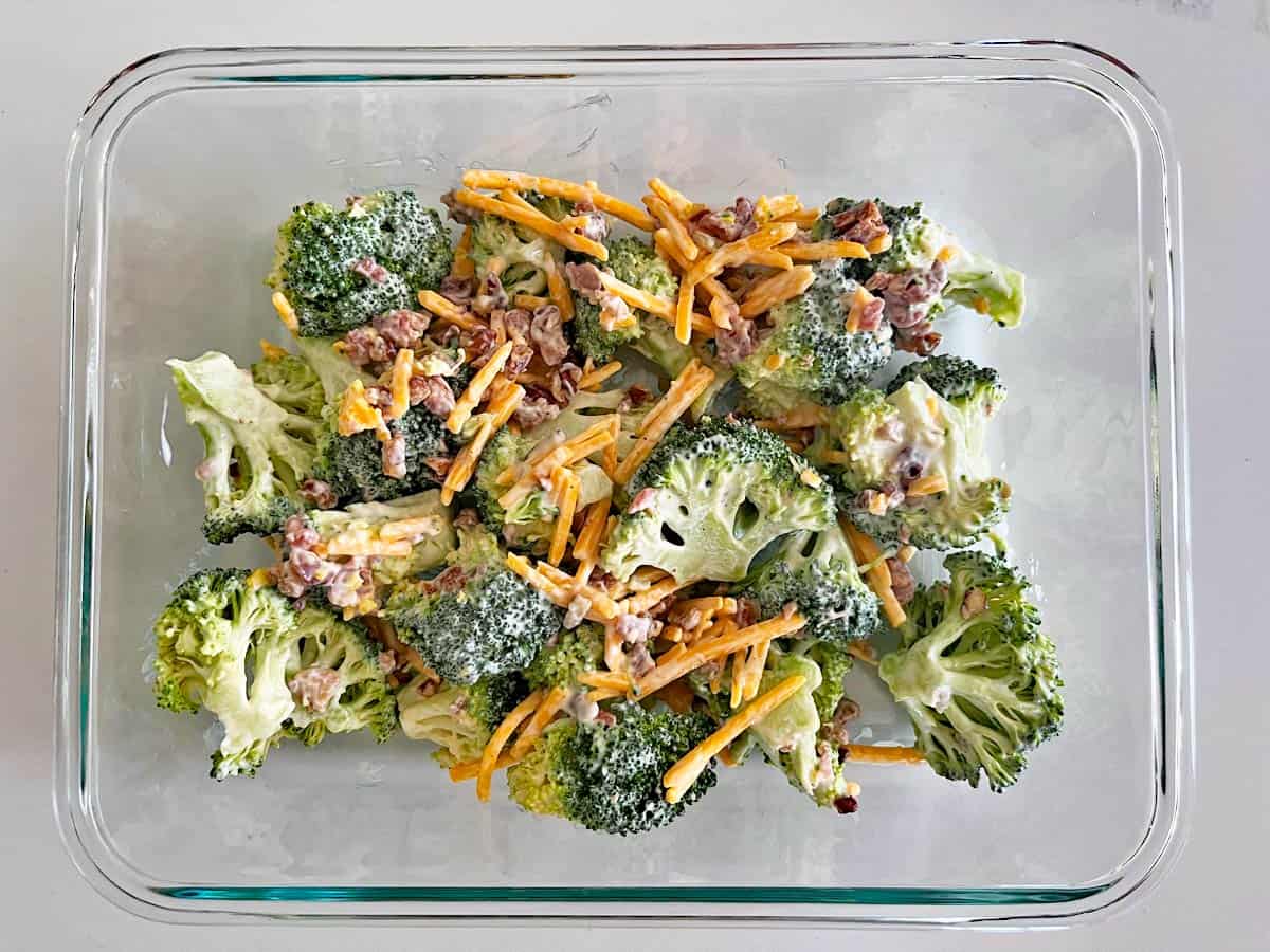 Broccoli salad leftovers are kept in a glass food storage container.