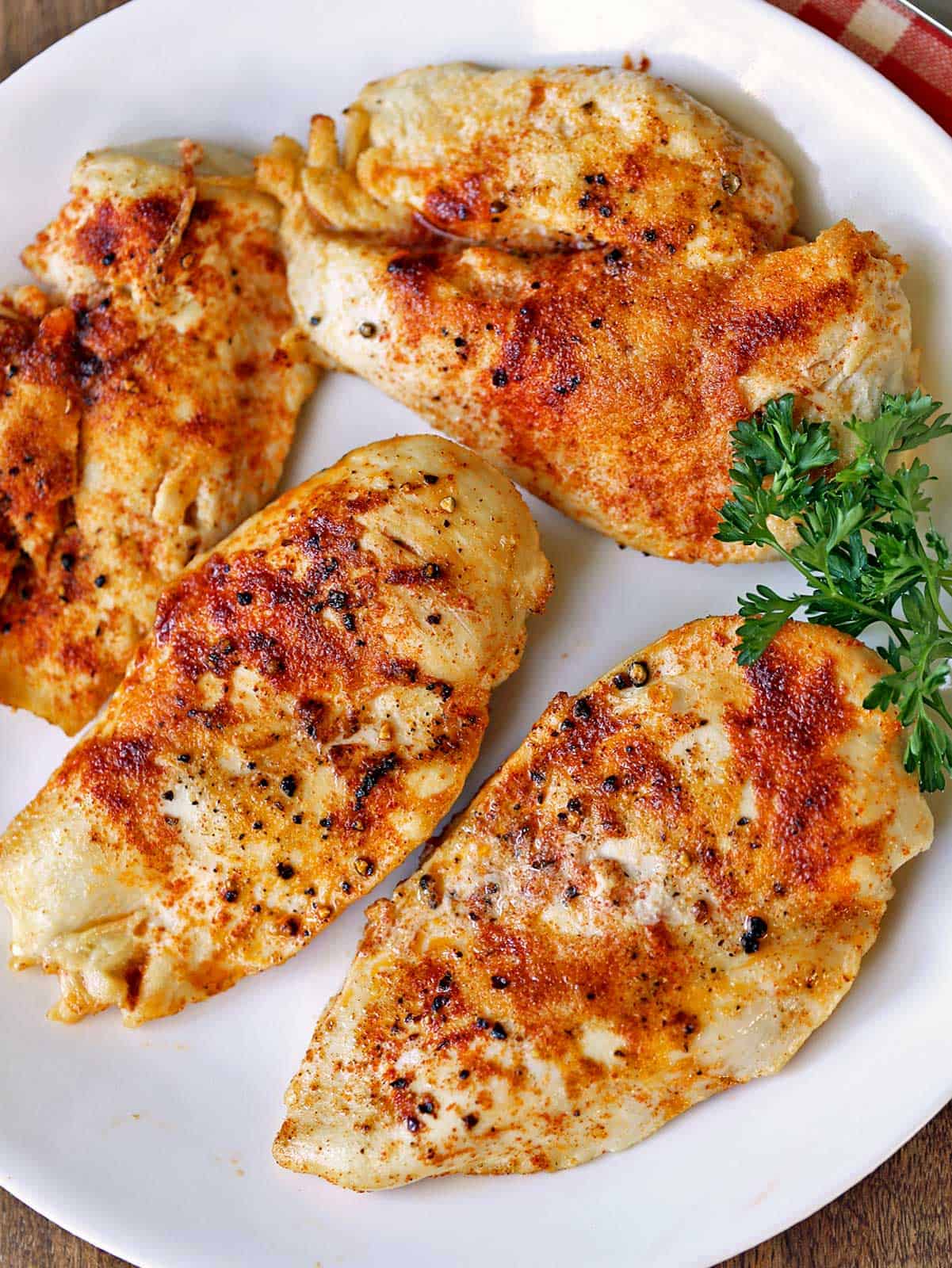 Broiled chicken is served on a plate.
