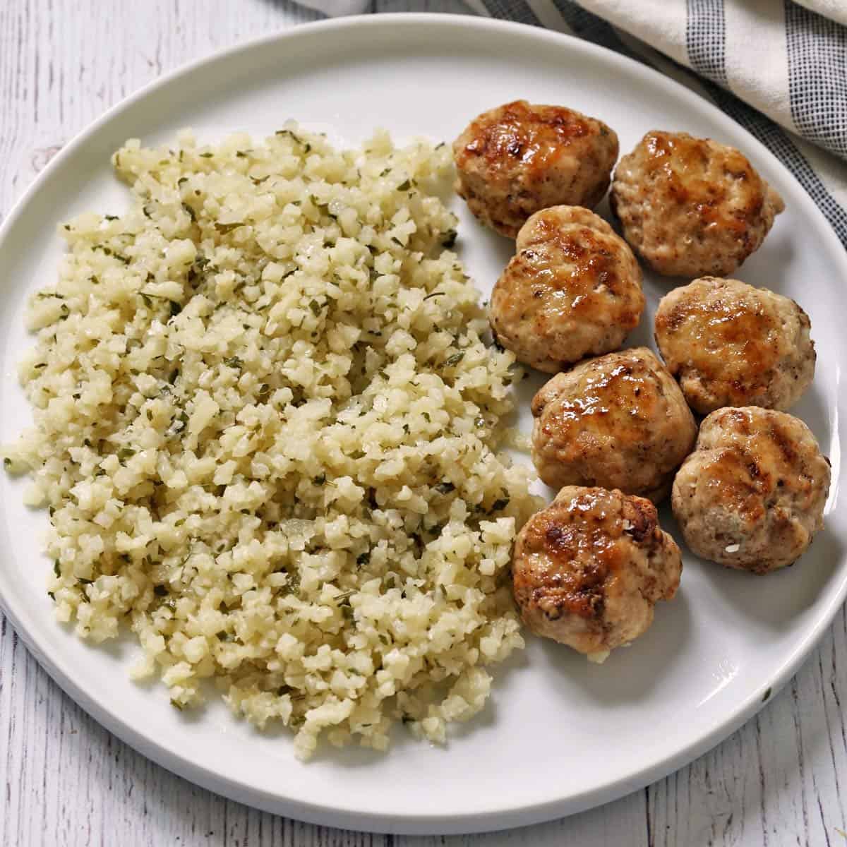 Chicken meatballs are served with cauliflower rice.