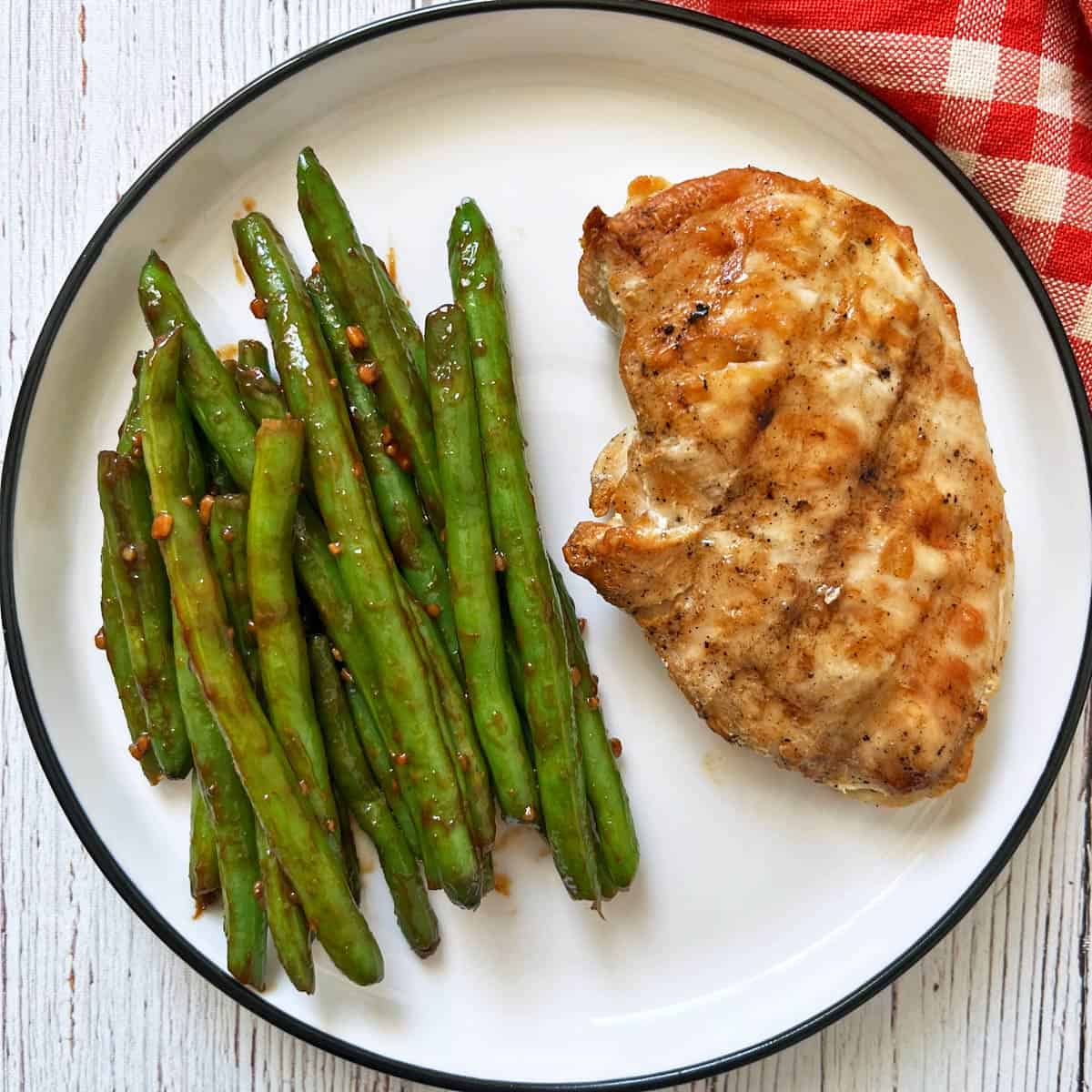 Asian green beans are served with grilled chicken.