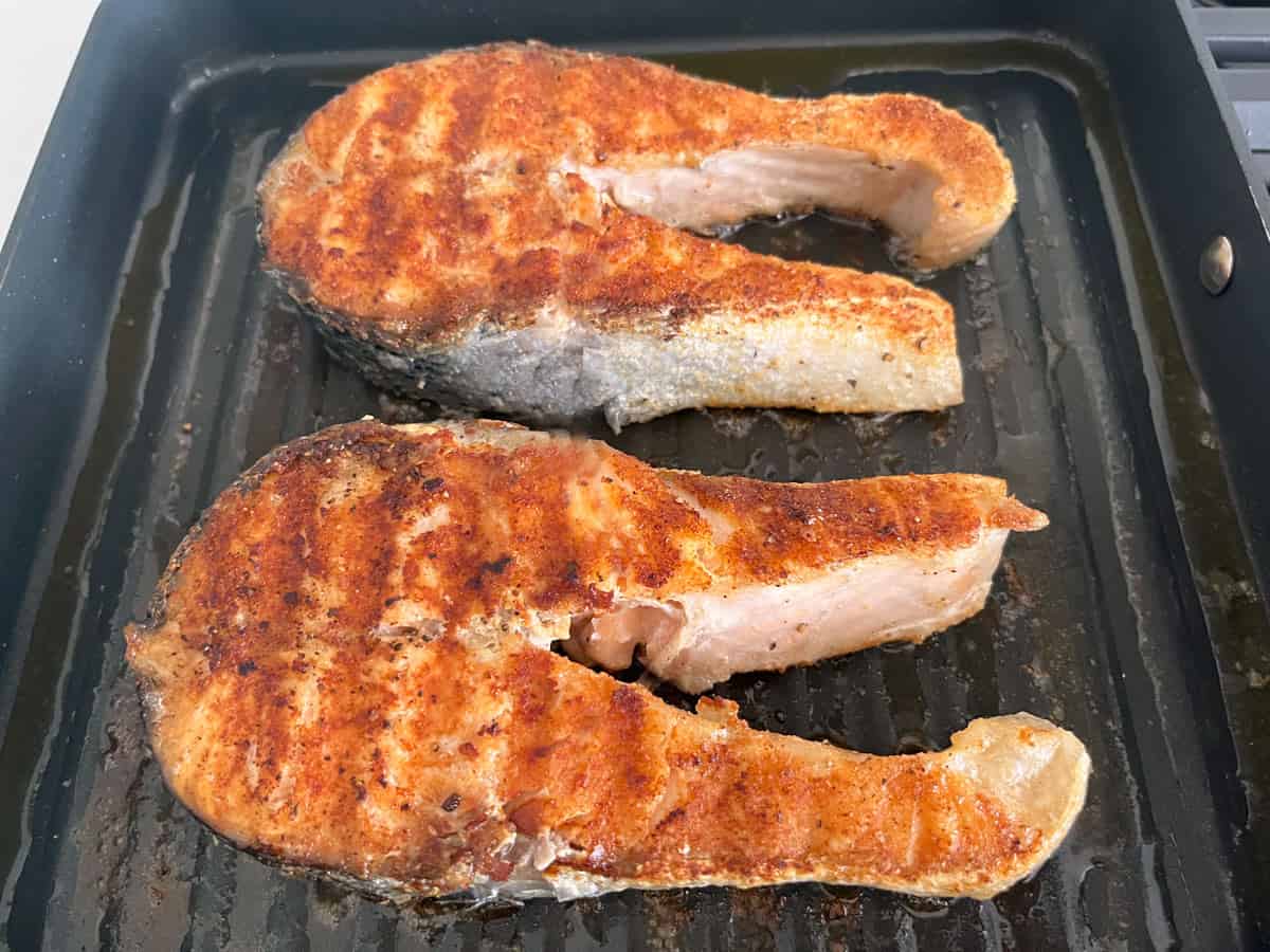 Large salmon steaks after spending a few minutes in the oven.