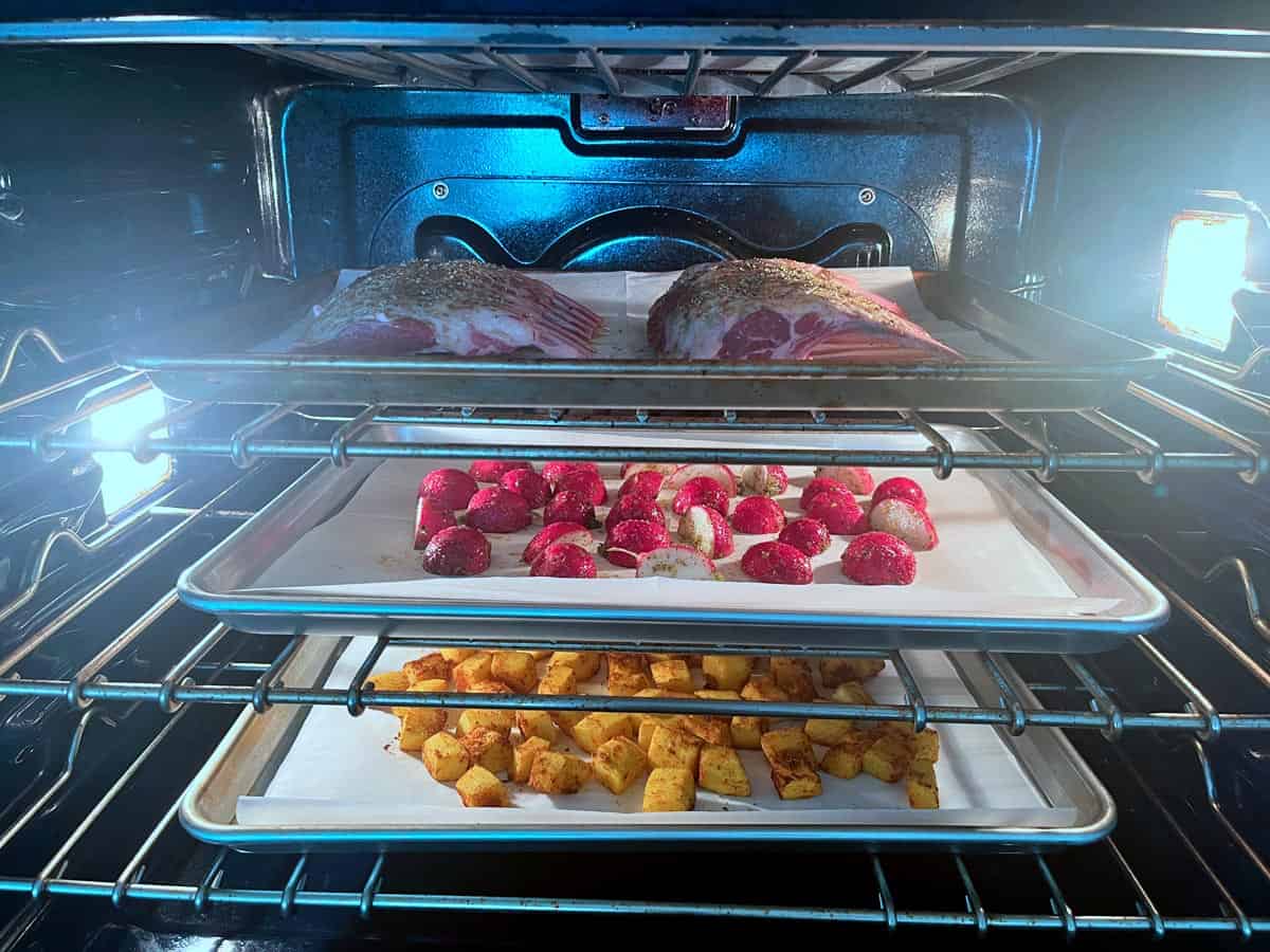 Rack of lamb, pumpkin, and radishes in the oven.