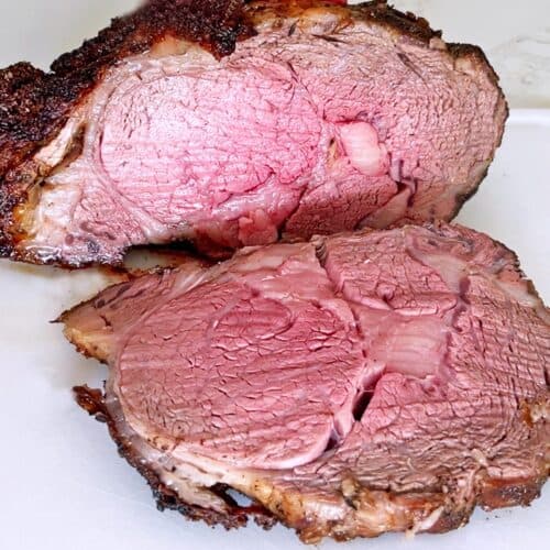 A sliced ribeye roast on a cutting board.