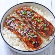 Teriyaki salmon is served in a bowl over cauliflower rice.
