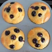Four almond flour muffins in a muffin pan.