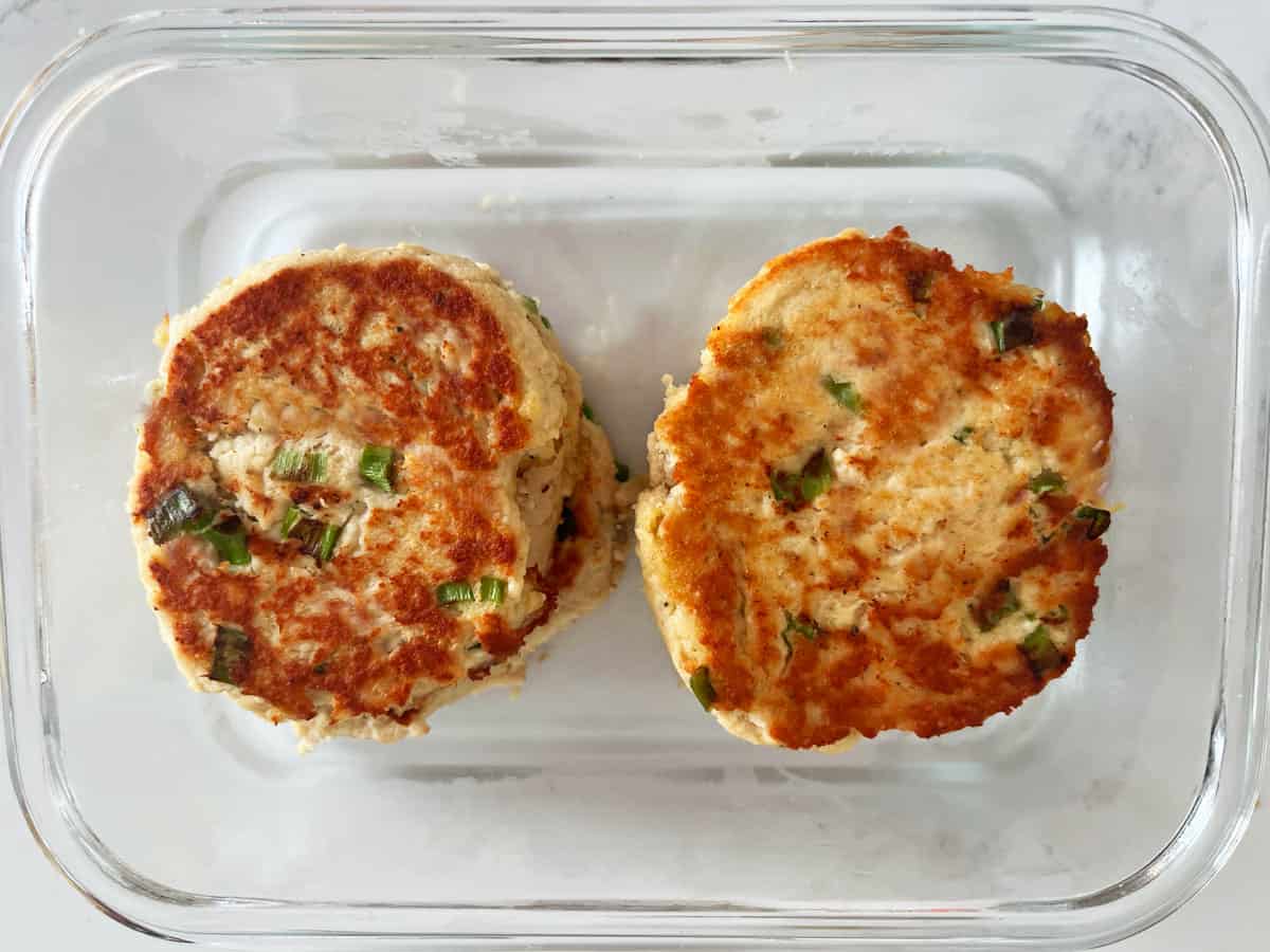 Leftover turkey patties made with scallions in a glass food storage container.
