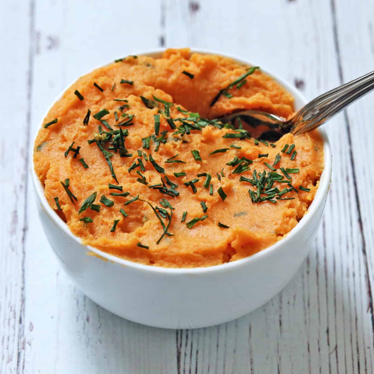 Savory mashed sweet potatoes are topped with chives.