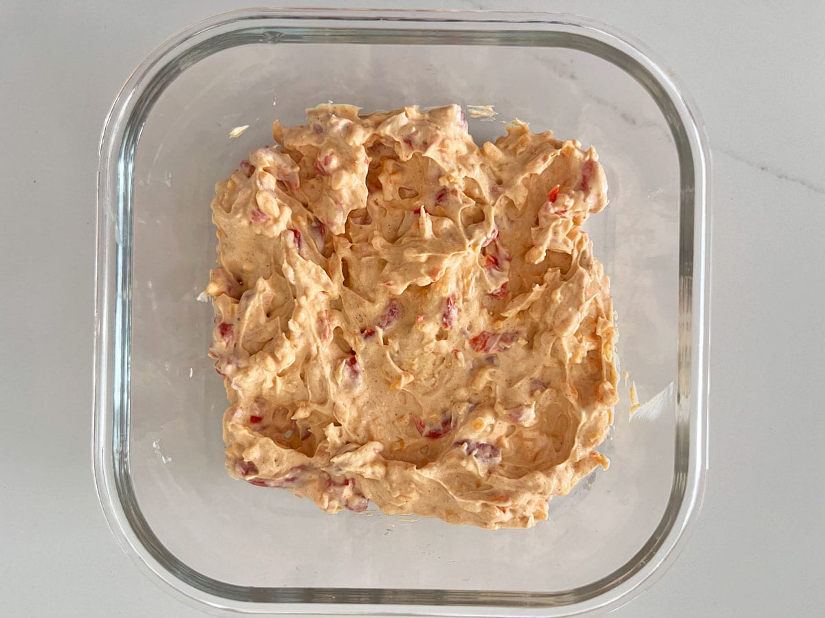 Storing leftover pimento cheese in a glass food storage container.