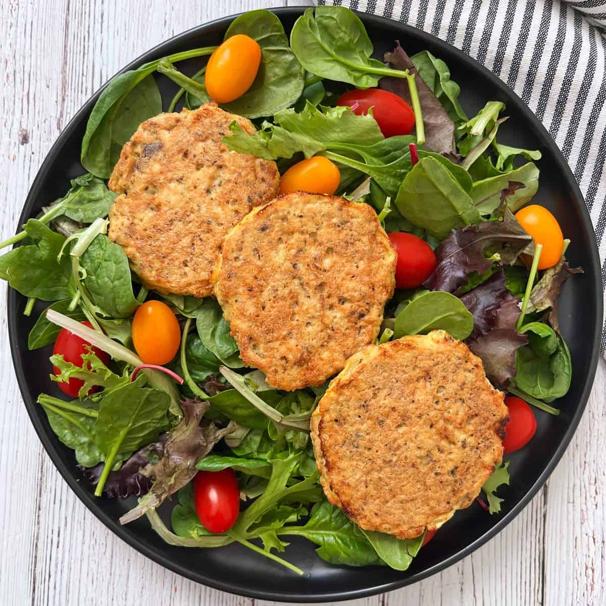 Salmon cakes are served on a salad.