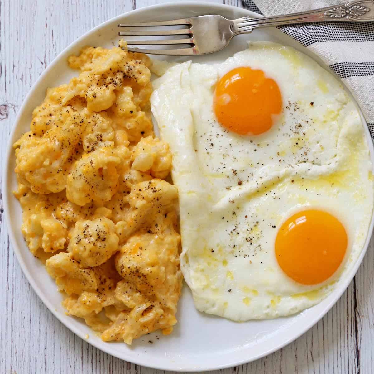 Creamy fried eggs are served with cauliflower mac and cheese.