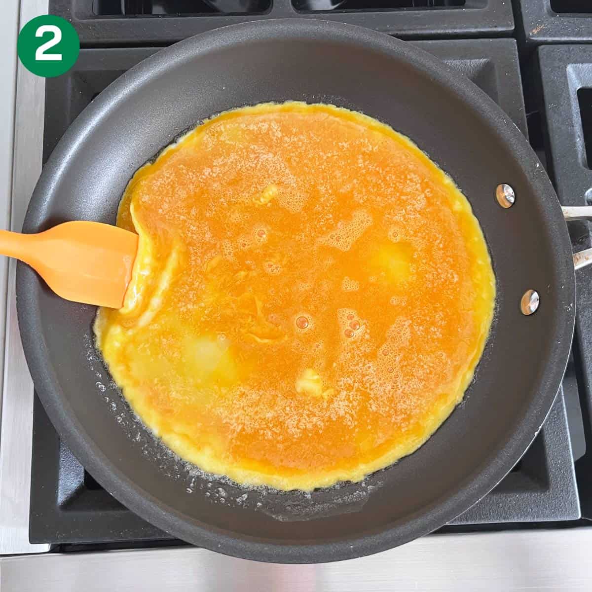 Lifting the omelette's edges.