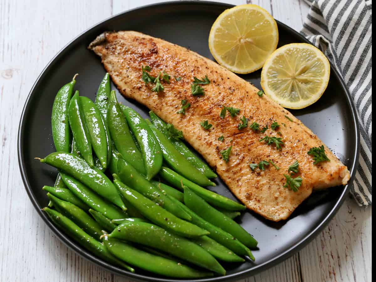 Rainbow trout is served with sugar snap peas.