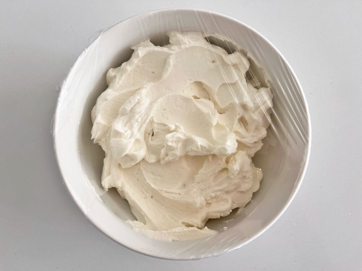 Keto whipped cream is covered with cling wrap.