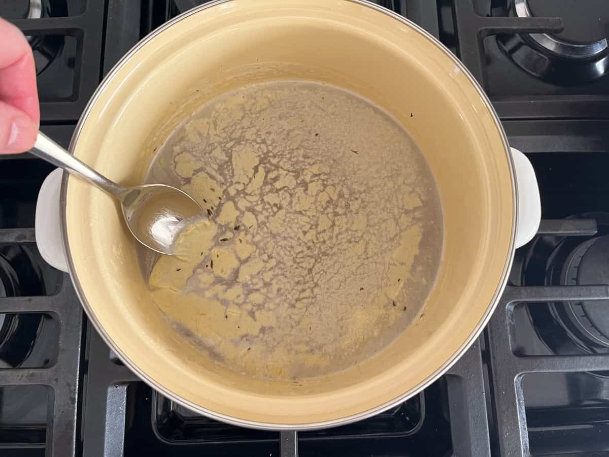 Skimming the fat from turkey soup.