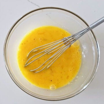 Whisking the eggs in a bowl.
