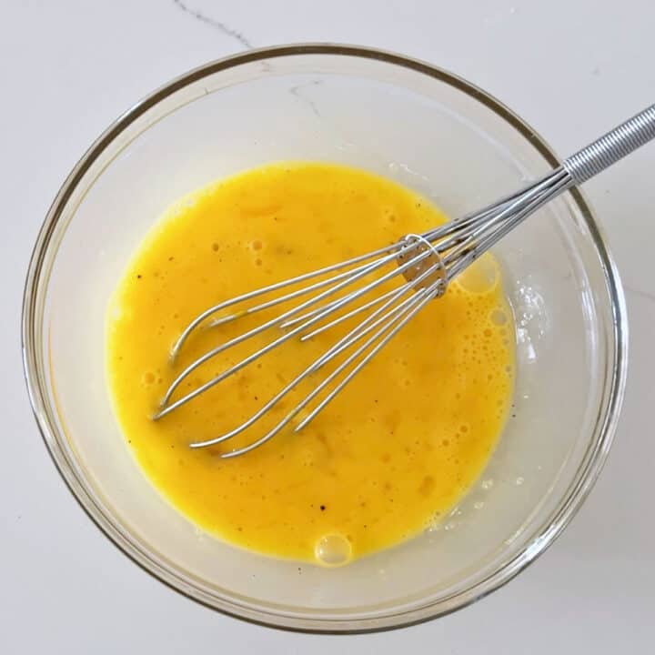 Whisking the eggs in a bowl.