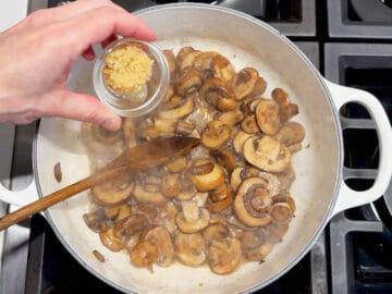 Adding garlic to the pot.