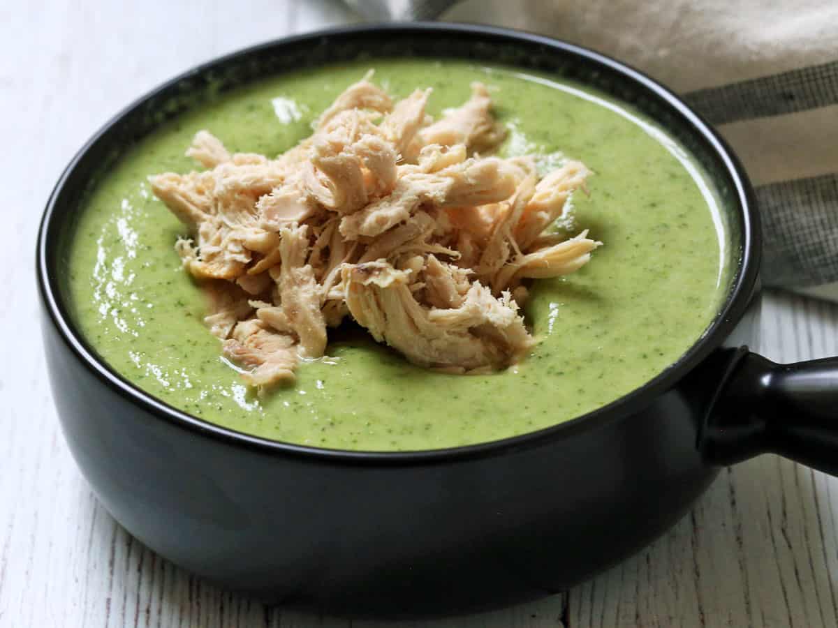Broccoli soup is topped with shredded chicken.