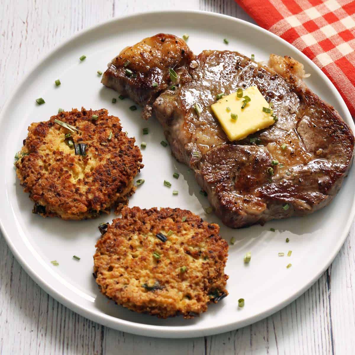 Cauliflower fritters are served with a steak.