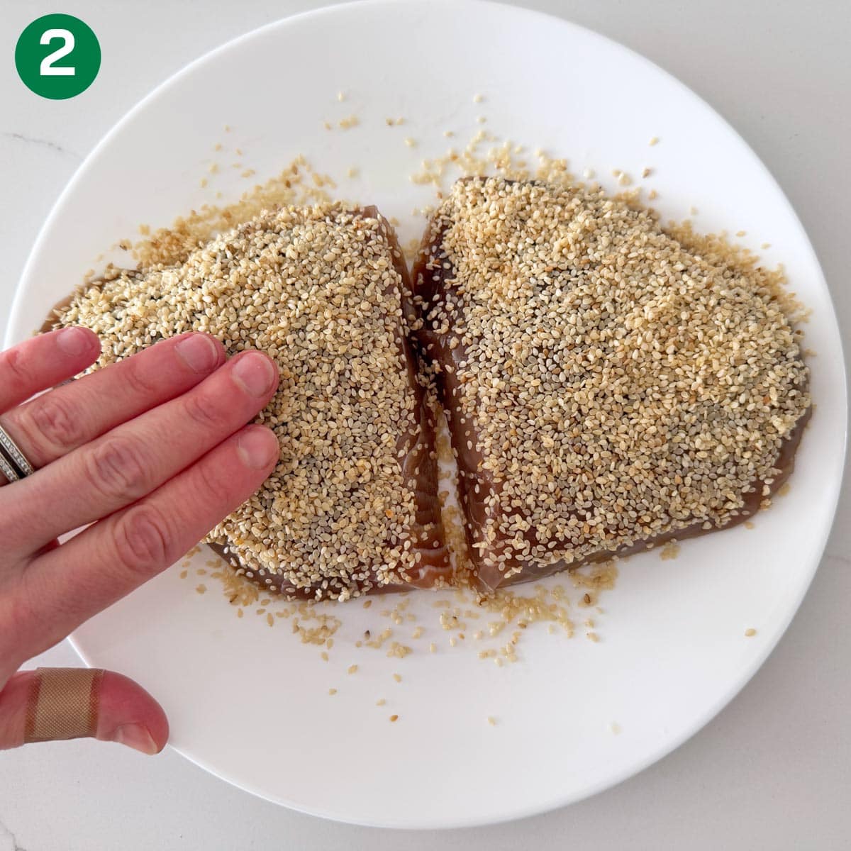 Dredging the tuna in sesame seeds.
