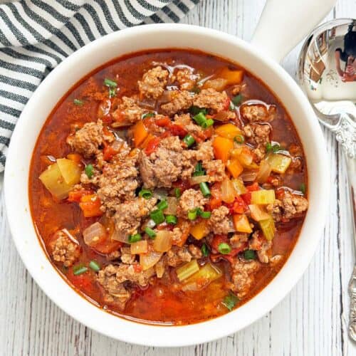 Hamburger soup is served in a white bowl.