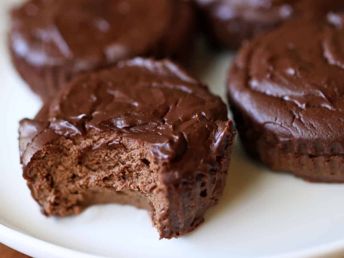 Mini chocolate cheesecakes are served on a white plate.