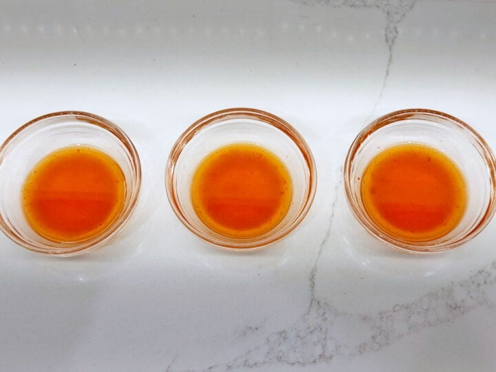 Three bowls with a vinegar and hot sauce marinade.