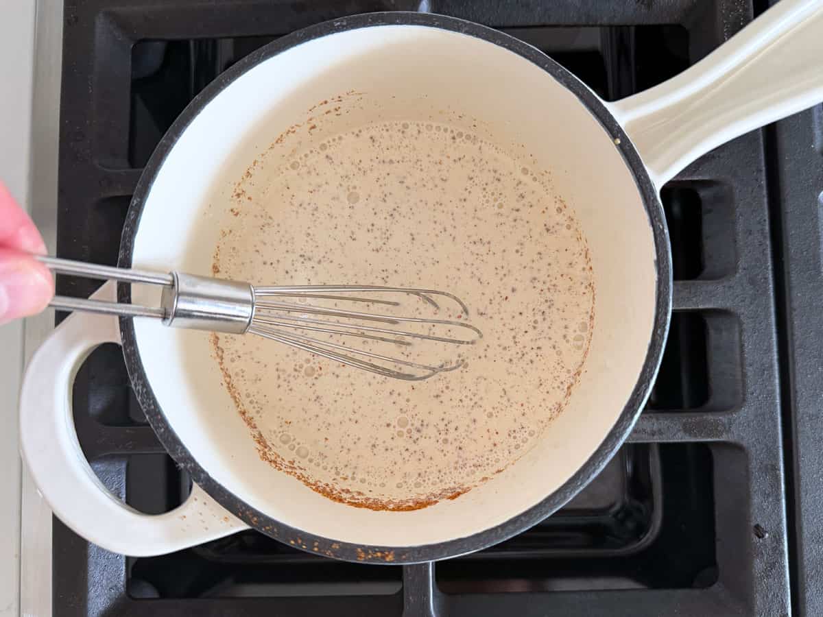 Whisking the heavy cream with Dijon and spices.