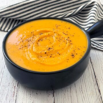 Butternut squash soup is topped with freshly ground black pepper.