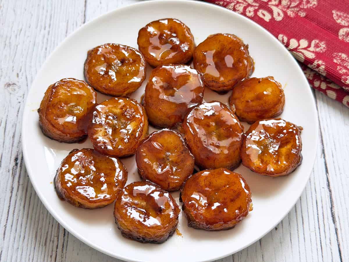 Fried bananas with honey on a plate.