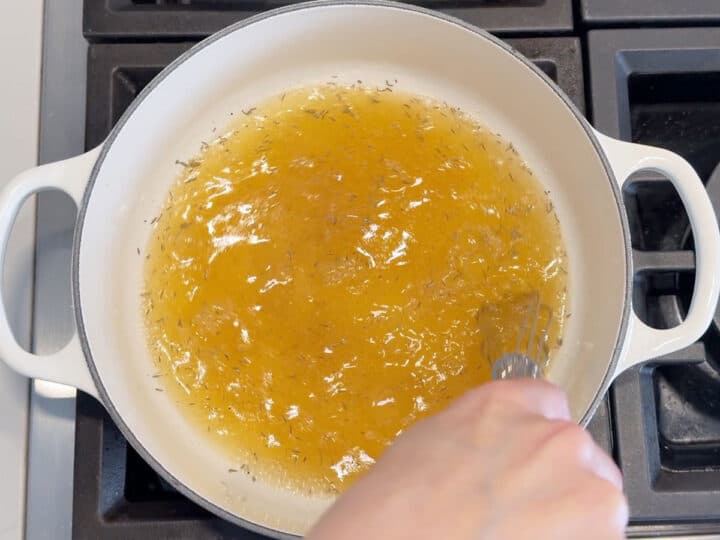Mixing chicken broth and spices.
