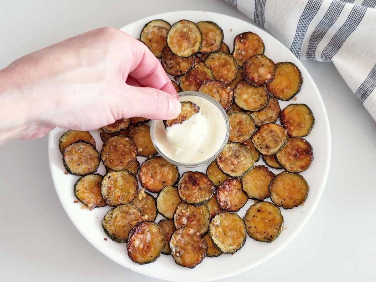 Zucchini chips are served with a dip.
