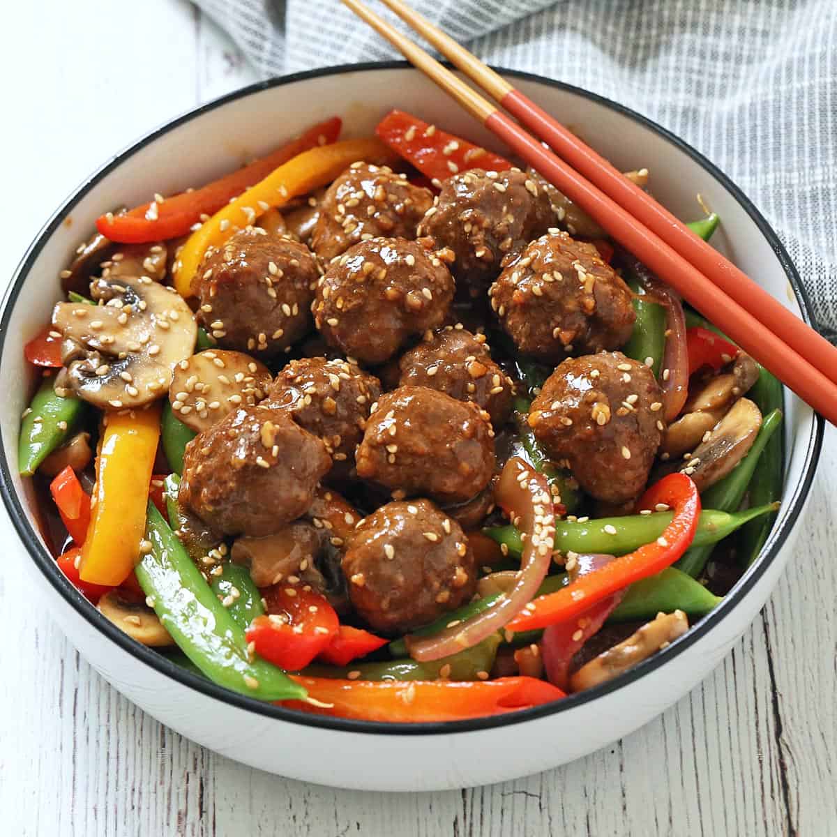 Asian meatballs are served with stir-fried veggies.