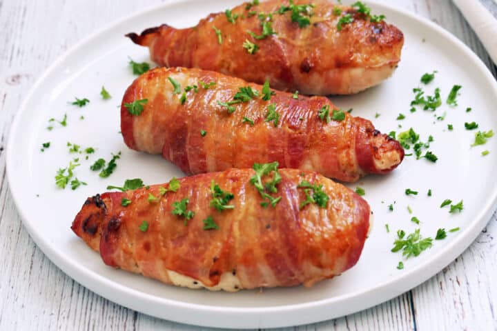Bacon wrapped chicken breast is served.