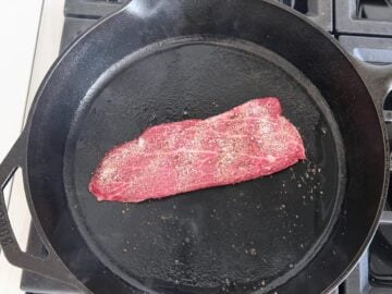 Flat iron steak in a cast-iron skillet.