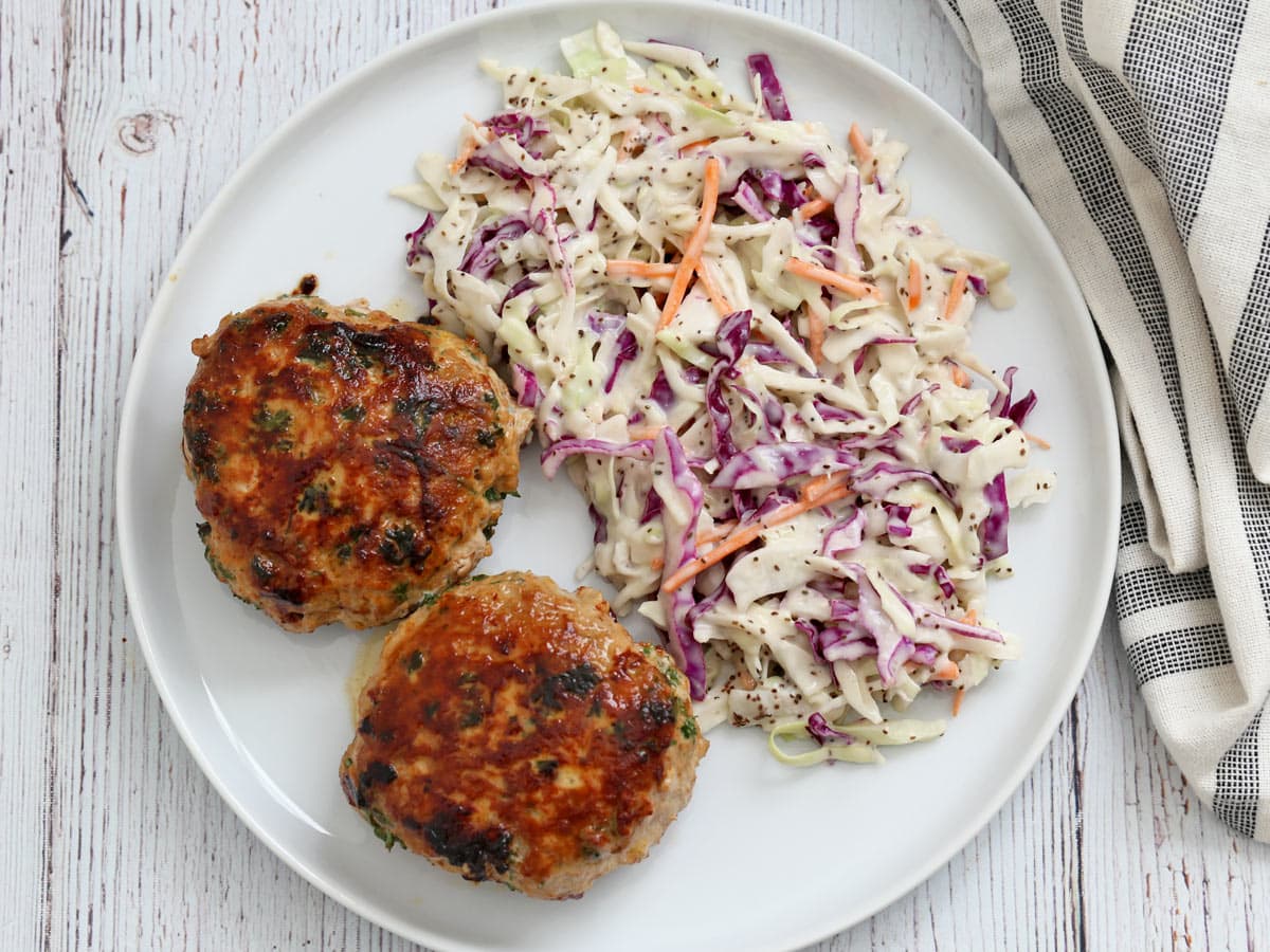 Turkey burgers are served with coleslaw.