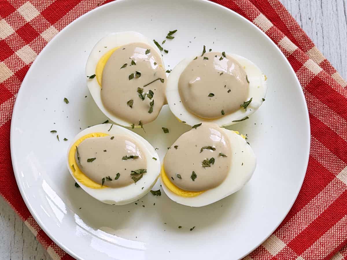 Hard-boiled eggs are topped with tahini sauce.